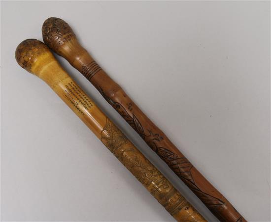 Two Oriental carved walking sticks Longest 90cm.